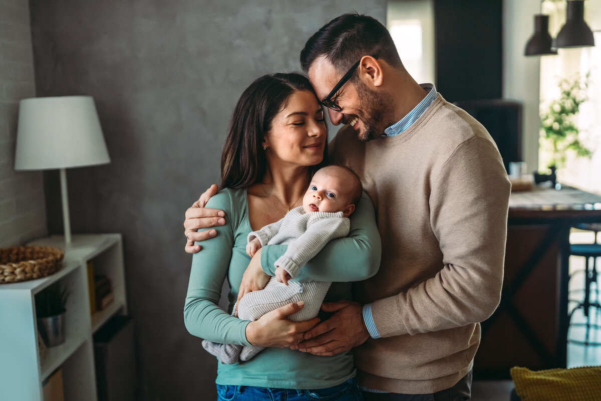 Happy parents lovingly holding their newborn baby at home after a successful fertility journey