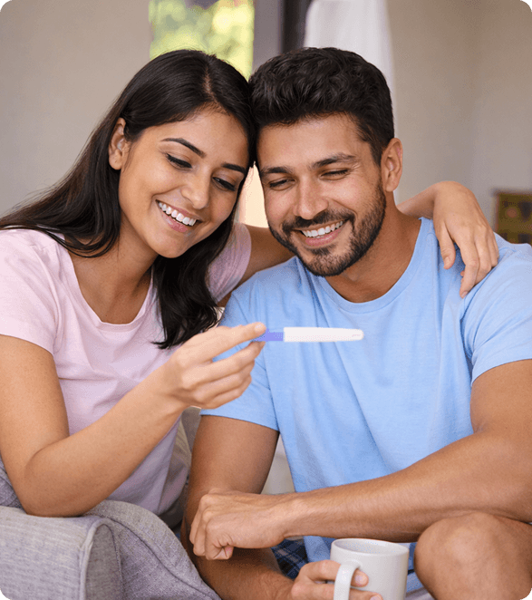 Happy couple holding a positive pregnancy test after successful IUI fertility treatment at Wellspring IVF Ahmedabad